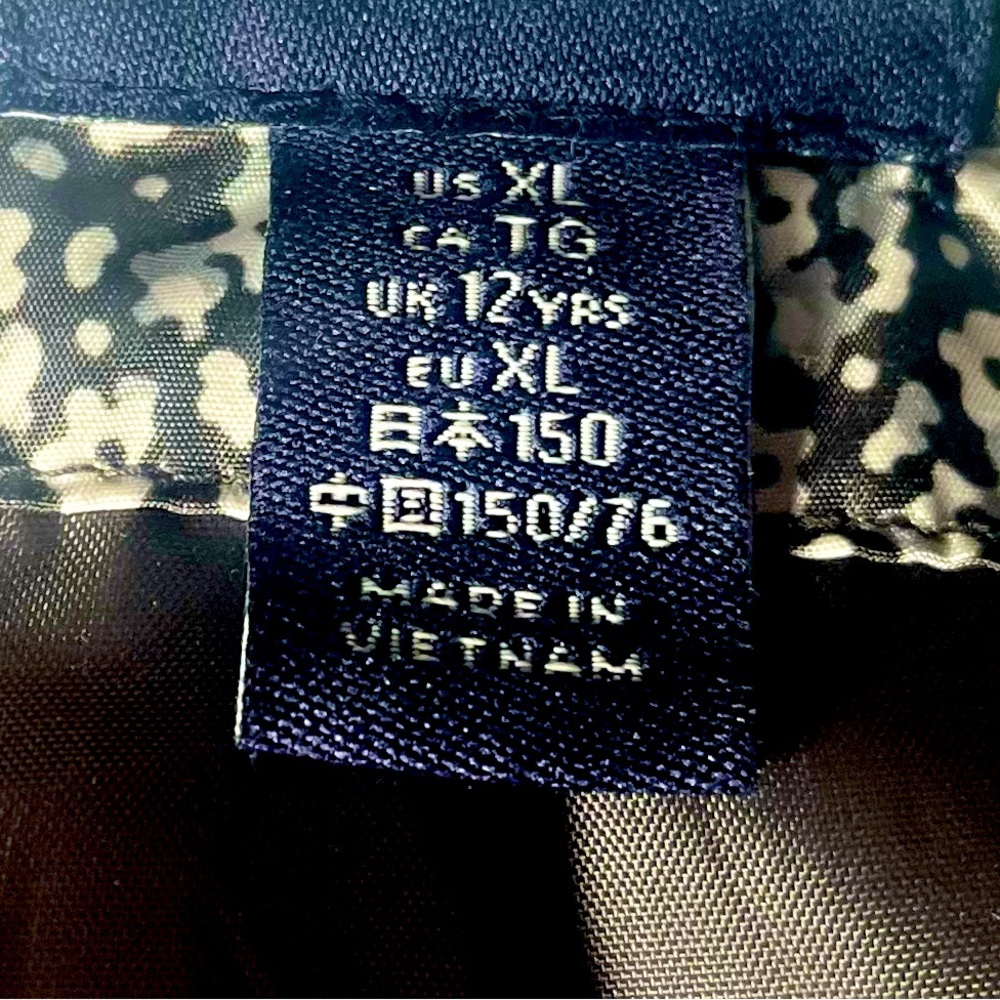 Black and white flower design on vest. with buttons on pockets.